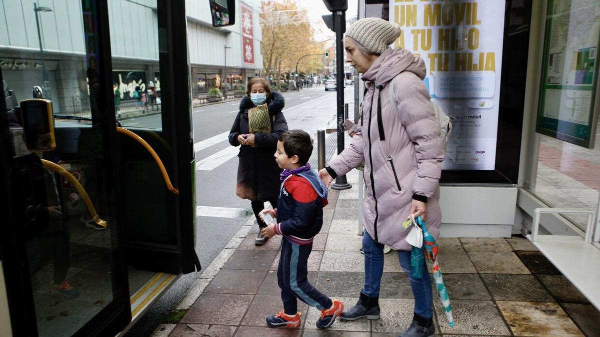 Un menor y su madre acceden a uno de los autobuses de Tuvisa.