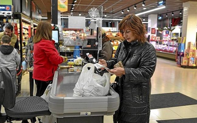 Una mujer comprueba el tique en un supermercado. Una mujer comprueba el tique en un supermercado.