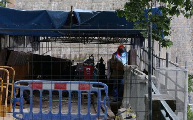 Un operario trabajando en el arreglo de la pasarela.