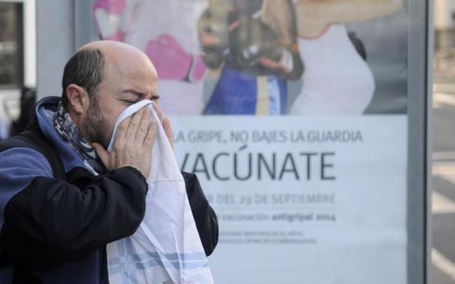 Imagen de archivo de un hombre sonándose la nariz junto a una marquesina.