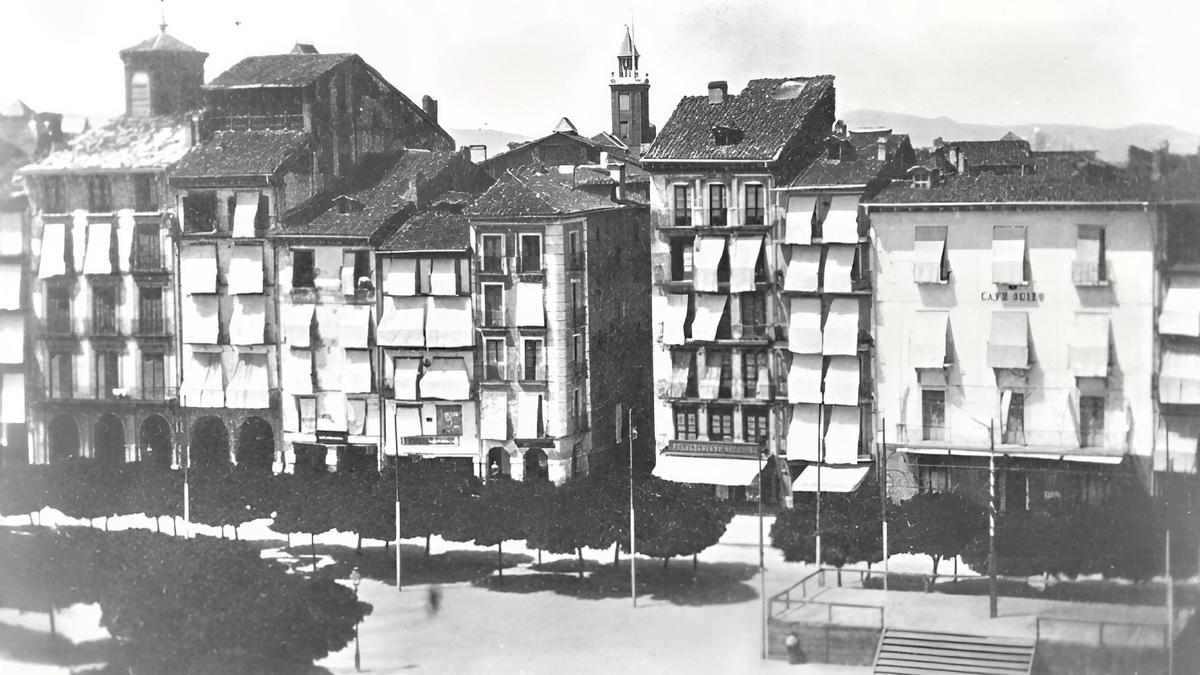 Año 1870, el lado oeste de la plaza con la entrada a la calle San Nicolás y a la izquierda de ella la casa de Labairu, número 34, que sería derribada en 1939 y sustituida por el edificio actual que lleva el número 1 de San Nicolás. A la derecha de la imagen, la antigua Casa del Toril, entonces ocupada por el Café Suizo. Archivo Municipal de Pamplona.