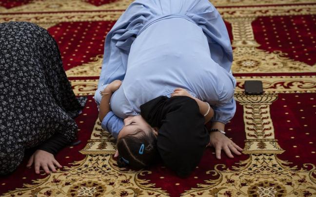 Una mujer reza en el funeral de dos de los hombres asesinados en Albuquerque.