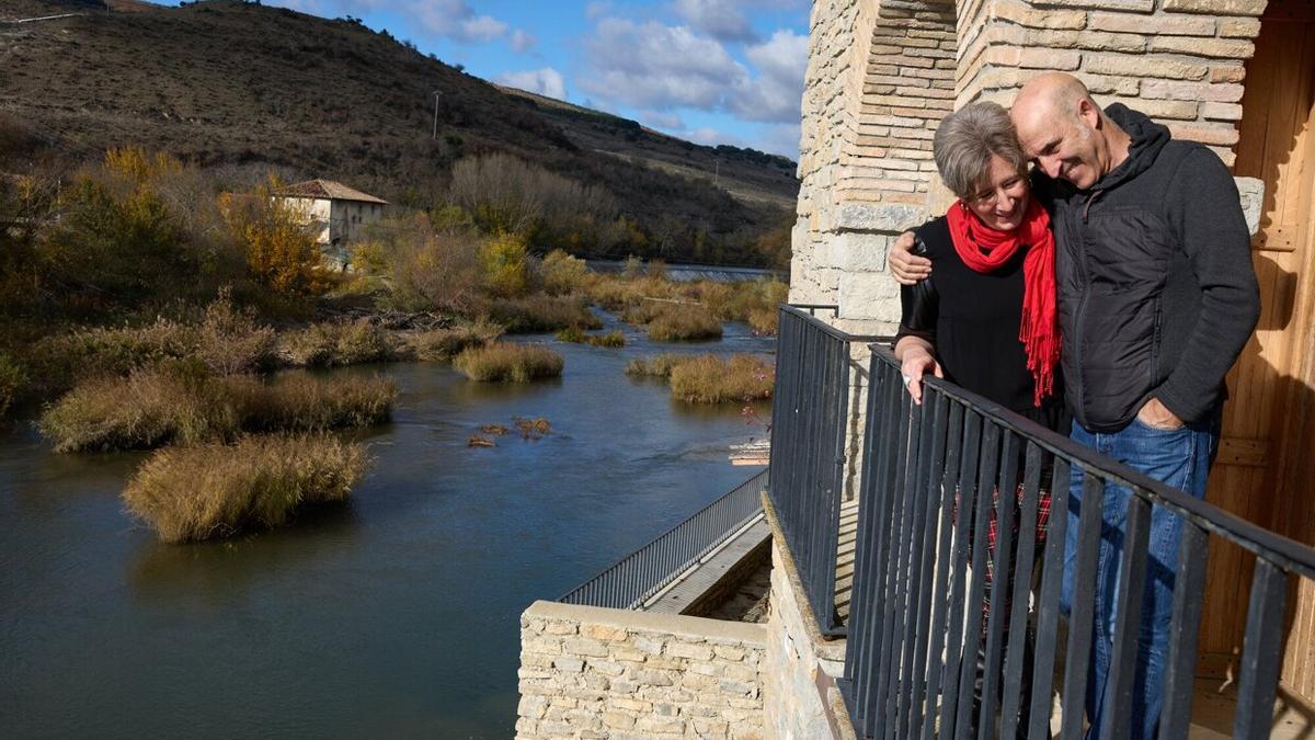 Abrazo cariñoso de Isabel y Piter, asomados a un balcón que mira al río Arakil.