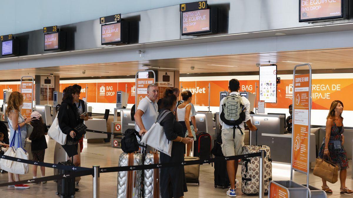 Pasajeros esperando en mostradores de easyJet en el aeropuerto de Barcelona