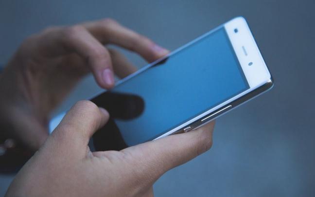 Una persona utiliza un tel&eacute;fono m&oacute;vil