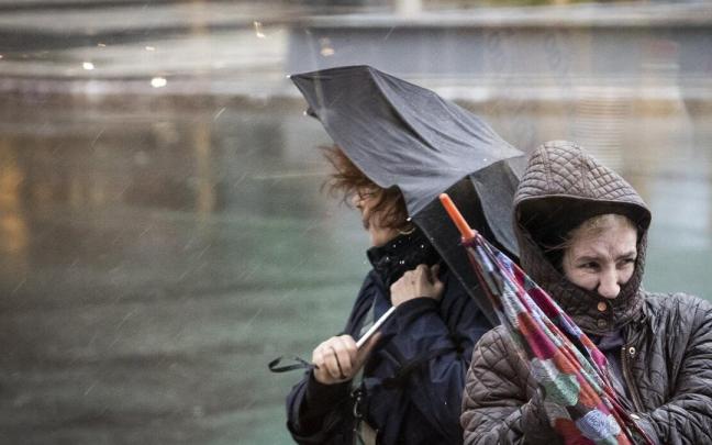 Dos mujeres tratan de protegerse este martes en Donostia de las fuertes rachas de viento y de las intensas lluvias que ha traído el temporal 'Gerard'. Dos mujeres tratan de protegerse este martes en Donostia de las fuertes rachas de viento y de las intensas lluvias que ha traído el temporal 'Gerard'.