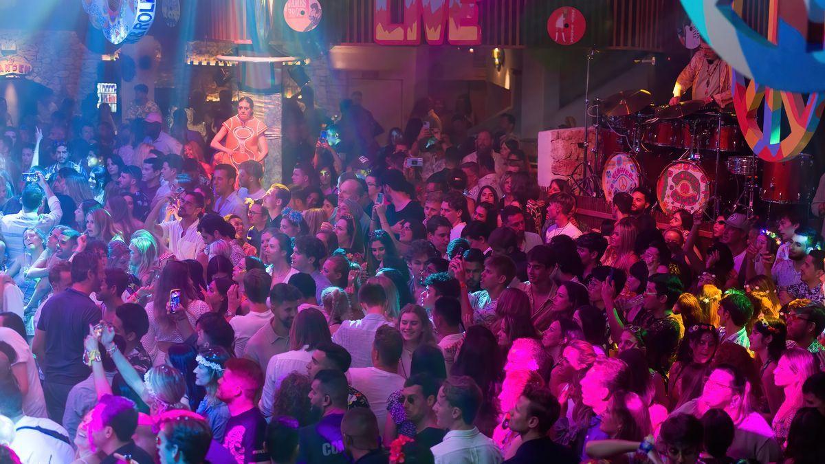 Decenas de jóvenes bailan en una discoteca.