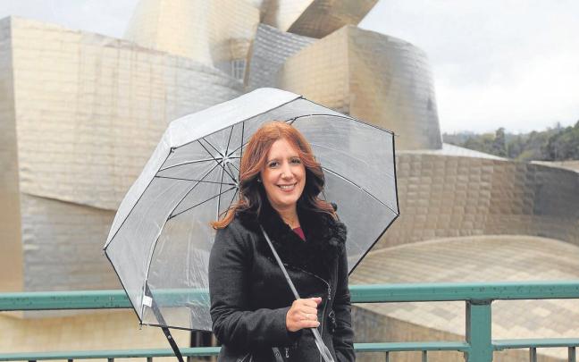 Dolores Redondo posa en el Museo Guggenheim en 2014. Arriba, la portada del libro. | FOTO: PABLO VI&Ntilde;AS