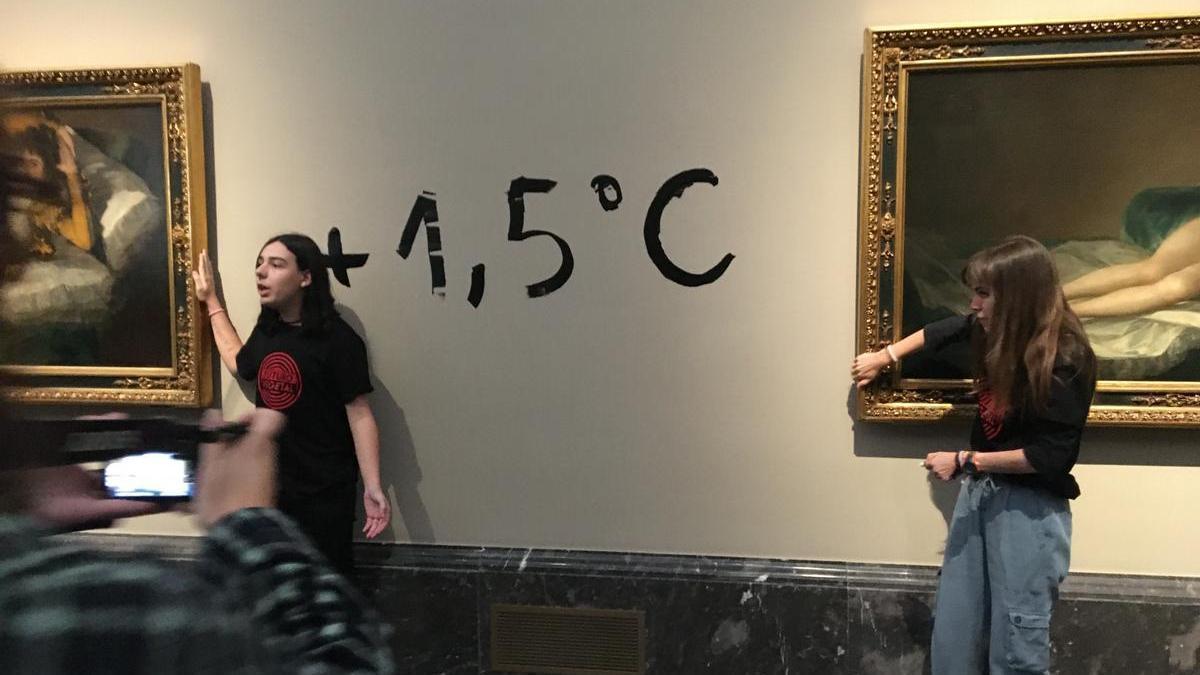 Dos jóvenes se pegan al marco de 'La maja desnuda' y 'La maja vestida' en el Museo Nacional del Prado.
