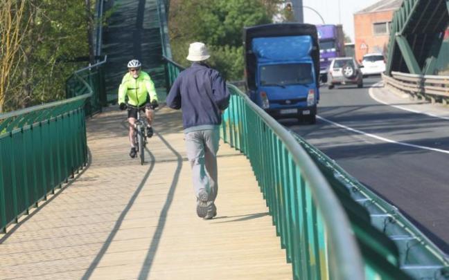 Un hombre y un ciclista pasean por la pasarela peatonal de Landaben que conecta el Parque Fluvial de Pamplona con el de la Comarca en Arazuri, junto a la carretera del polígono (PA-30). Un hombre y un ciclista pasean por la pasarela peatonal de Landaben que conecta el Parque Fluvial de Pamplona con el de la Comarca en Arazuri, junto a la carretera del polígono (PA-30).
