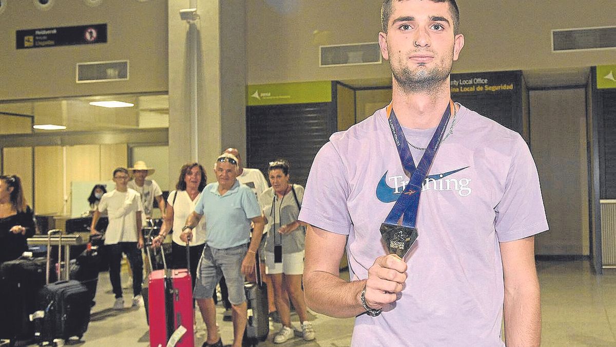 Asier Martínez posa con la medalla a su llegada al aeropuerto de Noain. | FOTO: IÑAKI PORTO