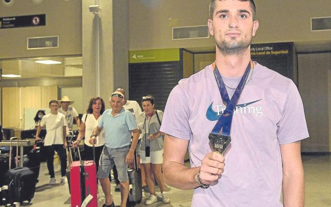 Asier Martínez posa con la medalla a su llegada al aeropuerto de Noain. | FOTO: IÑAKI PORTO