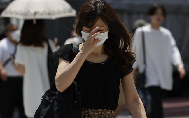 Una mujer camina por Tokyo (Japón). Una mujer camina por Tokyo (Japón).