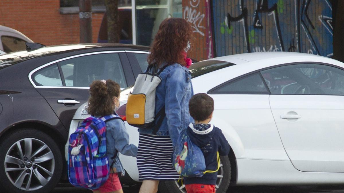 Una familia camina por un paso de cebra