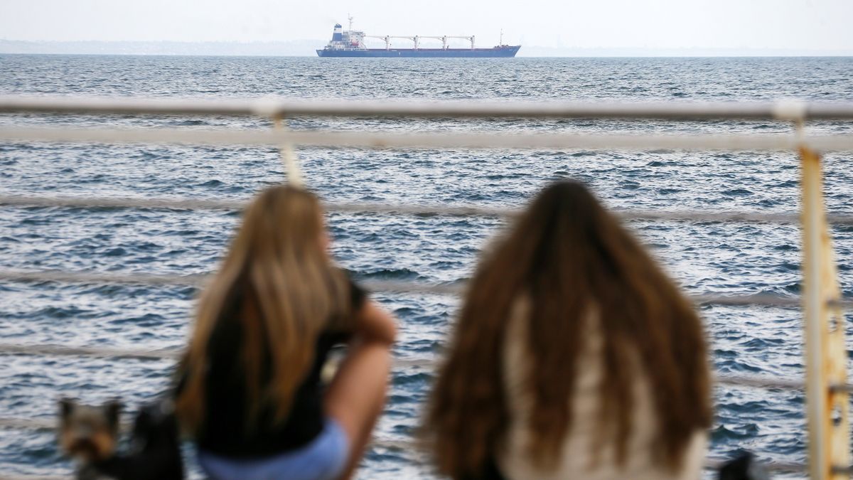 Dos jóvenes observan el buque Razoni desde el puerto de Odesa.