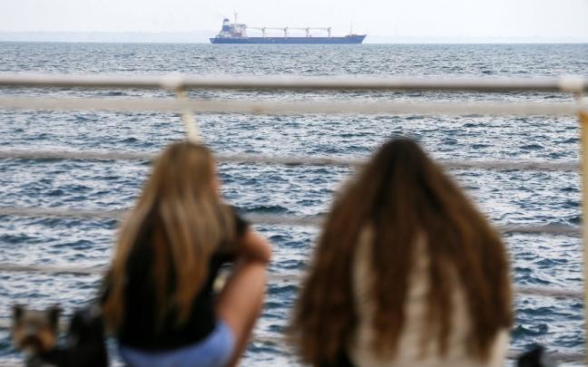 Dos jóvenes observan el buque Razoni desde el puerto de Odesa. Dos jóvenes observan el buque Razoni desde el puerto de Odesa.