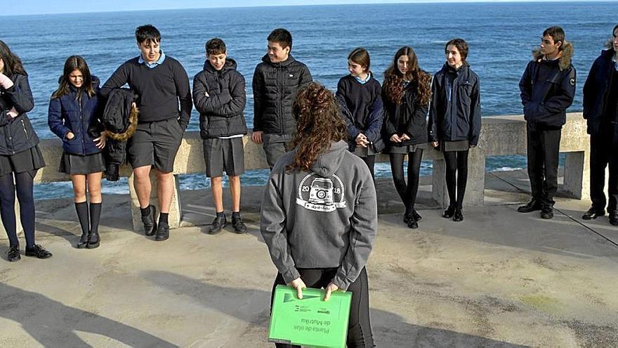 Un grupo de alumnos atendiendo a las explicaciones con el Cantábrico como testigo. | FOTO: X.M