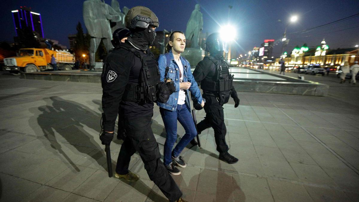 Tres policías detienen a un hombre en una protesta contra la guerra en Moscú.