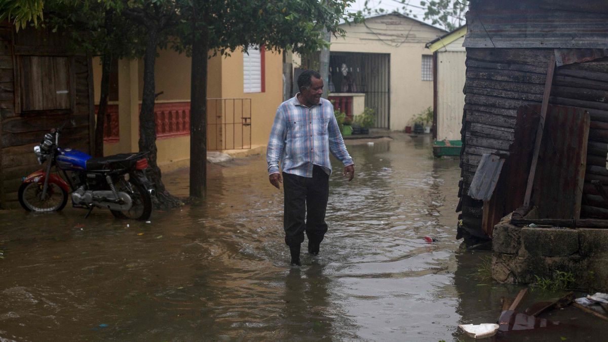 Un hombre pasea en una zona residencial inundada en Puerto Rico.