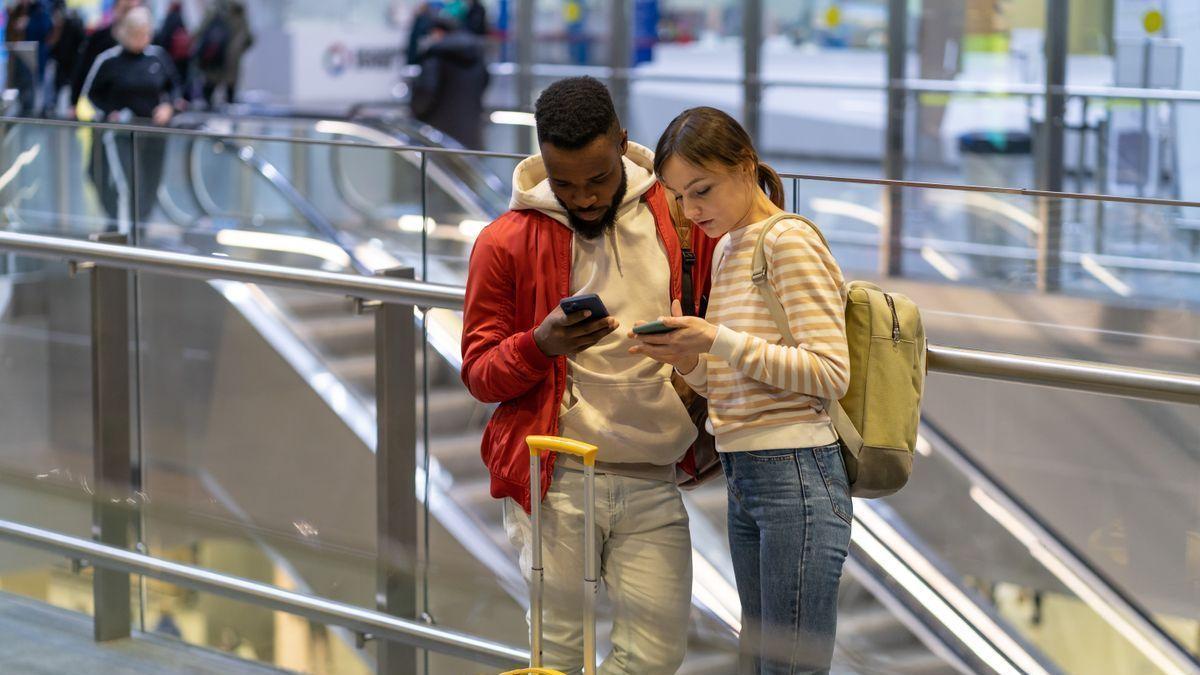Una pareja de viajeros trata de conectarse a una red móvil con la que poder acceder a internet.