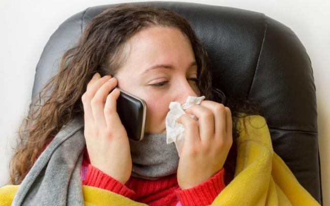 Mujer sonándose los mocos.