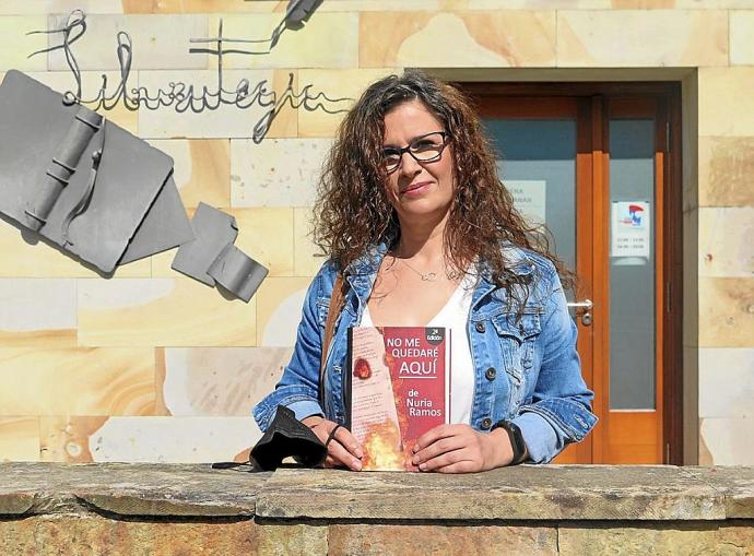 Nuria Ramos posa con su libro, delante de la biblioteca de Urretxu.