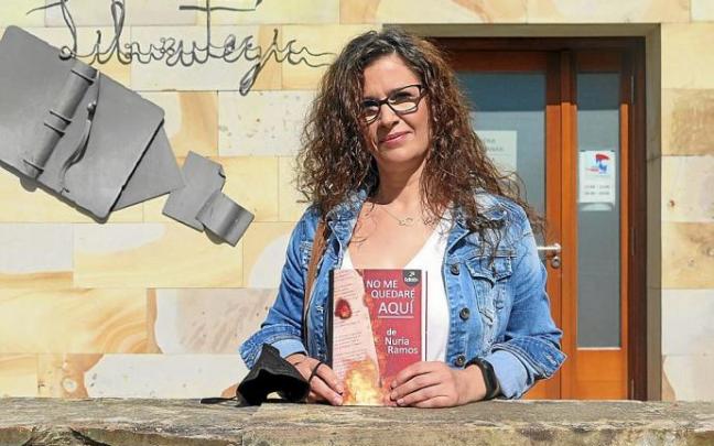 Nuria Ramos posa con su libro, delante de la biblioteca de Urretxu.