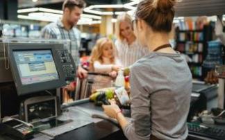 Una cajera cobra a los clientes en un supermercado. Una cajera cobra a los clientes en un supermercado.