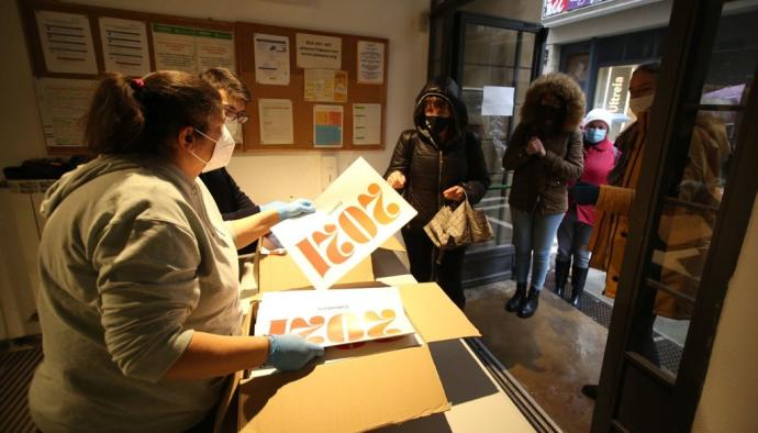 Gente haciendo cola para recoger el calendario de 2021 que edita el Ayuntamiento de Pamplona.