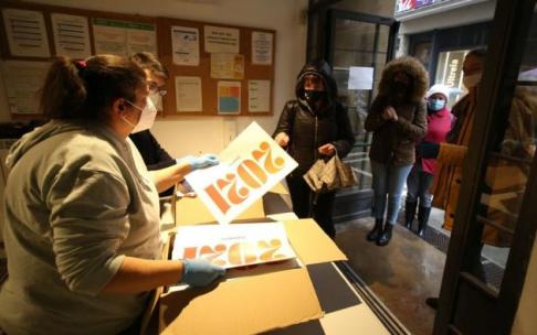 Gente haciendo cola para recoger el calendario de 2021 que edita el Ayuntamiento de Pamplona.