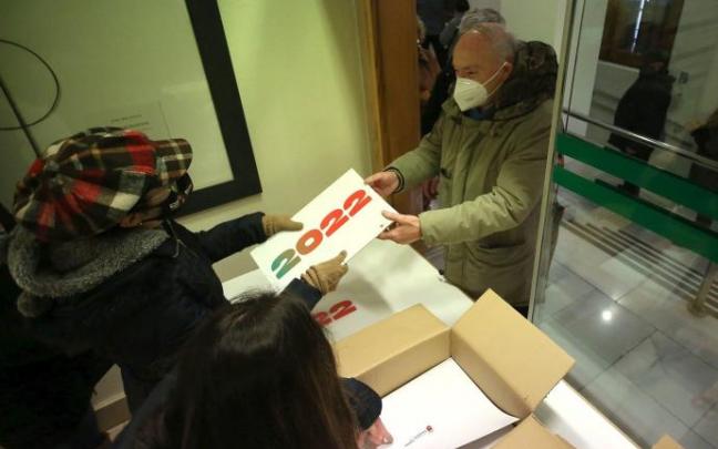 Gente recogiendo el calendario municipal de 2022