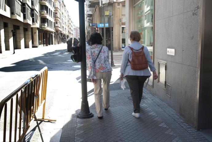 Dos personas, ajenas a la información, caminan por la calle Manuel Iradier