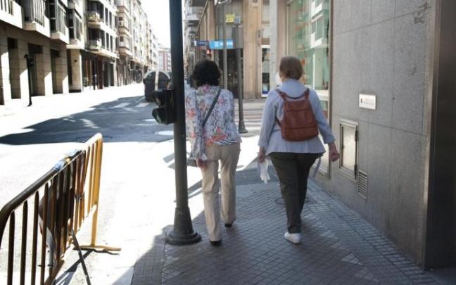 Dos personas, ajenas a la información, caminan por la calle Manuel Iradier