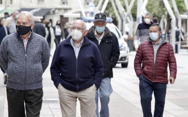 Personas andando por la calle con mascarilla para evitar contagios Personas andando por la calle con mascarilla para evitar contagios