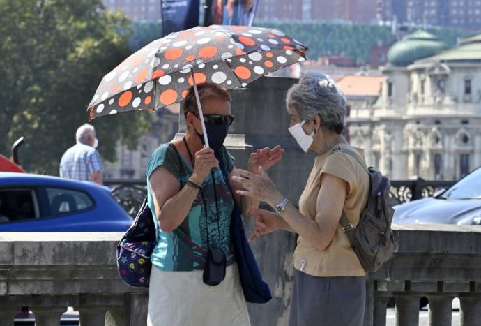 Dos mujeres con paraguas para cubrirse del sol en Bilbao