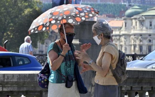 Dos mujeres con paraguas para cubrirse del sol en Bilbao Dos mujeres con paraguas para cubrirse del sol en Bilbao
