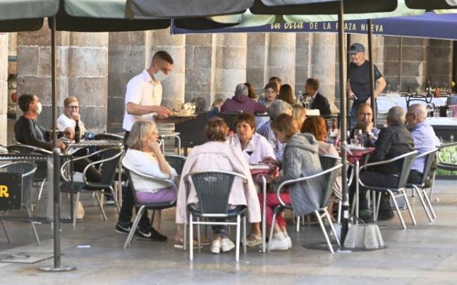 Un camarero sin relación con la información sirviendo mesas en una terraza. Un camarero sin relación con la información sirviendo mesas en una terraza.