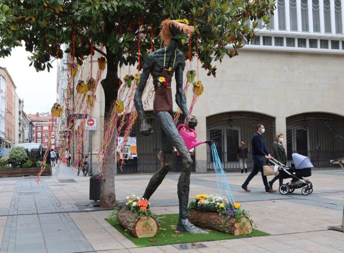 El monumento del caminante adornado con flores.