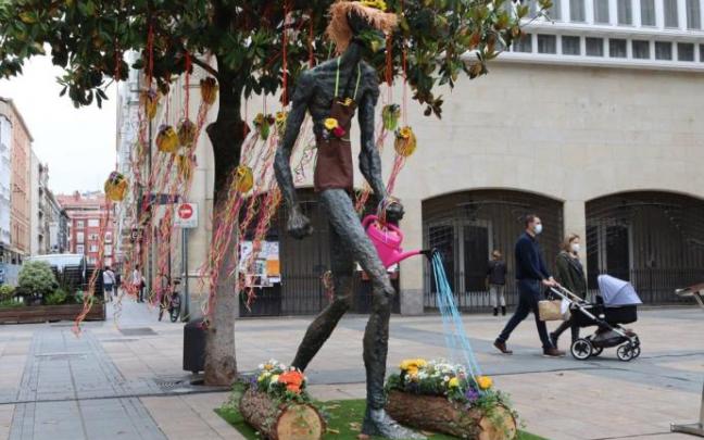 El monumento del caminante adornado con flores.
