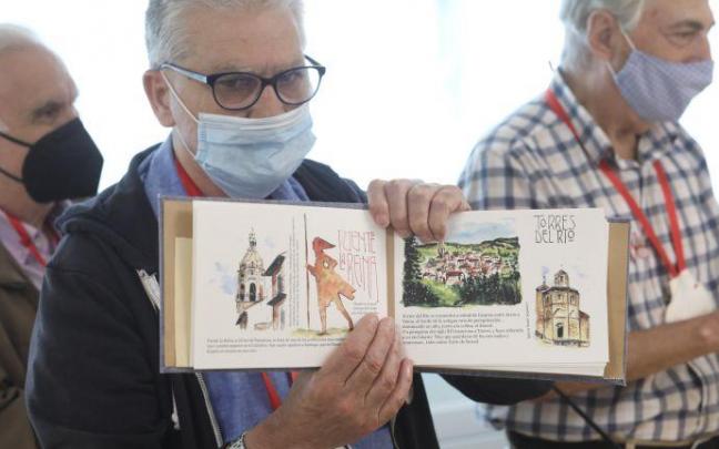 Uno de los residentes muestra el cuadernillo con ilustraciones al óleo de la llegada ficticia de los peregrinos a varios puntos del Camino de Santiago