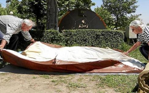 Dos personas plantan su tienda de campaña en una parcela del camping de Igeldo. Foto: Iker Azurmendi