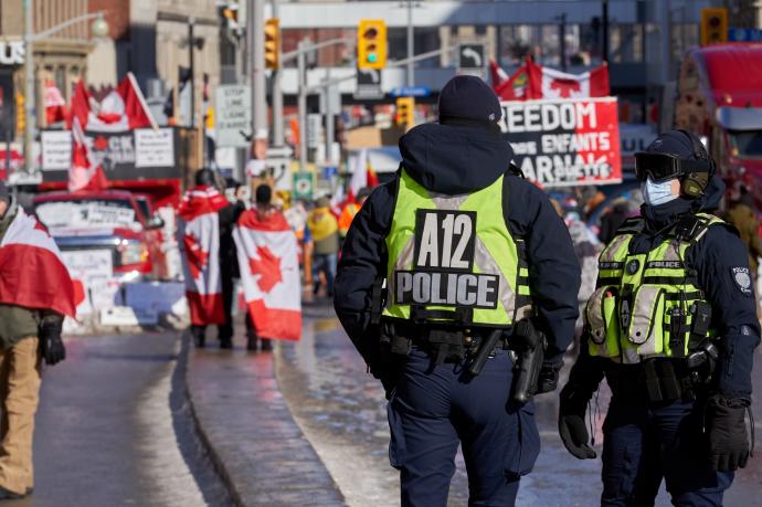 Dos agentes vigilian a los manifestantes antivacunas en Ottawa.