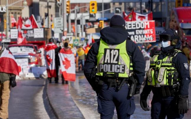 Dos agentes vigilian a los manifestantes antivacunas en Ottawa.