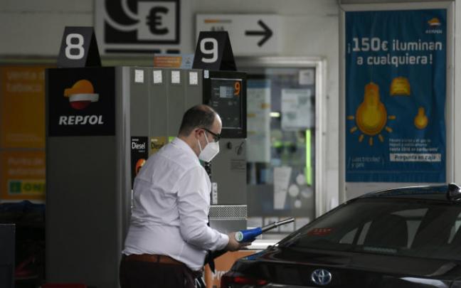 Un hombre echa gasolina a su coche. Un hombre echa gasolina a su coche.