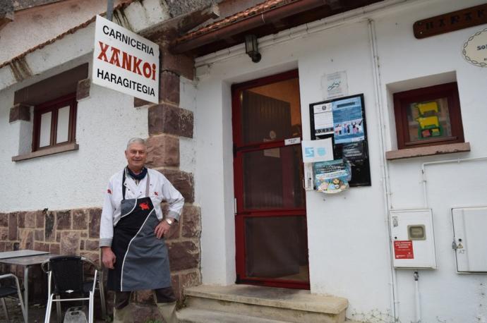 El carnicero 'Migueliko' Barberena posa tras el mostrador de la carnicería Xankoi, donde ha atendido durante 30 años.