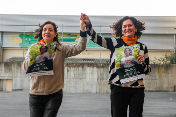 Mila Álvarez de Eulate y Mary Tere Guzmán con el cartel de la carrera de este domingo.