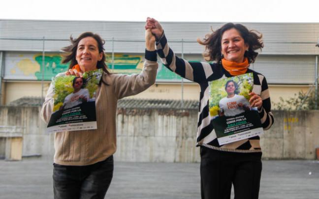 Mila Álvarez de Eulate y Mary Tere Guzmán con el cartel de la carrera de este domingo.