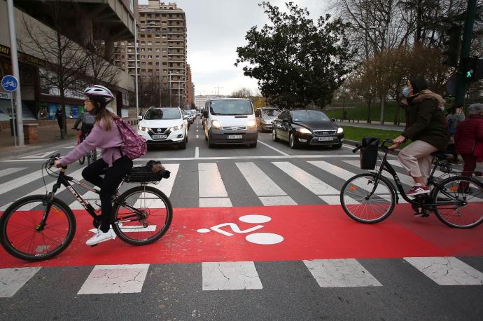 Dos personas circulan por el carril bici cerca del Edificio Singular.