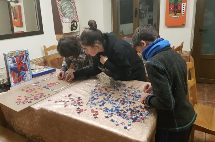 Niños haciendo un puzzle en la casa rural Basaula, en el Valle de Allín.