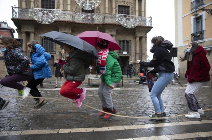 Un grupo de niños salta a la comba (algunos con paraguas), en la concentración de este viernes frente al ayuntamiento.